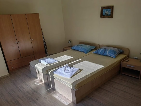 Twin bedroom with large brown wardrobe.