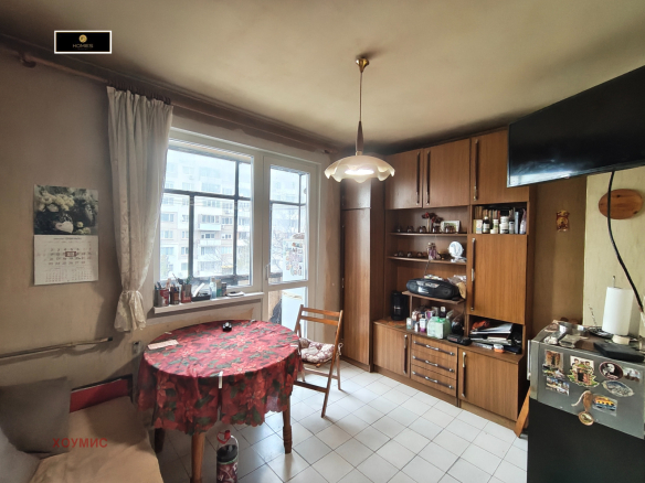 Светла кухня-трапезария с кръгла маса и дървена мебел