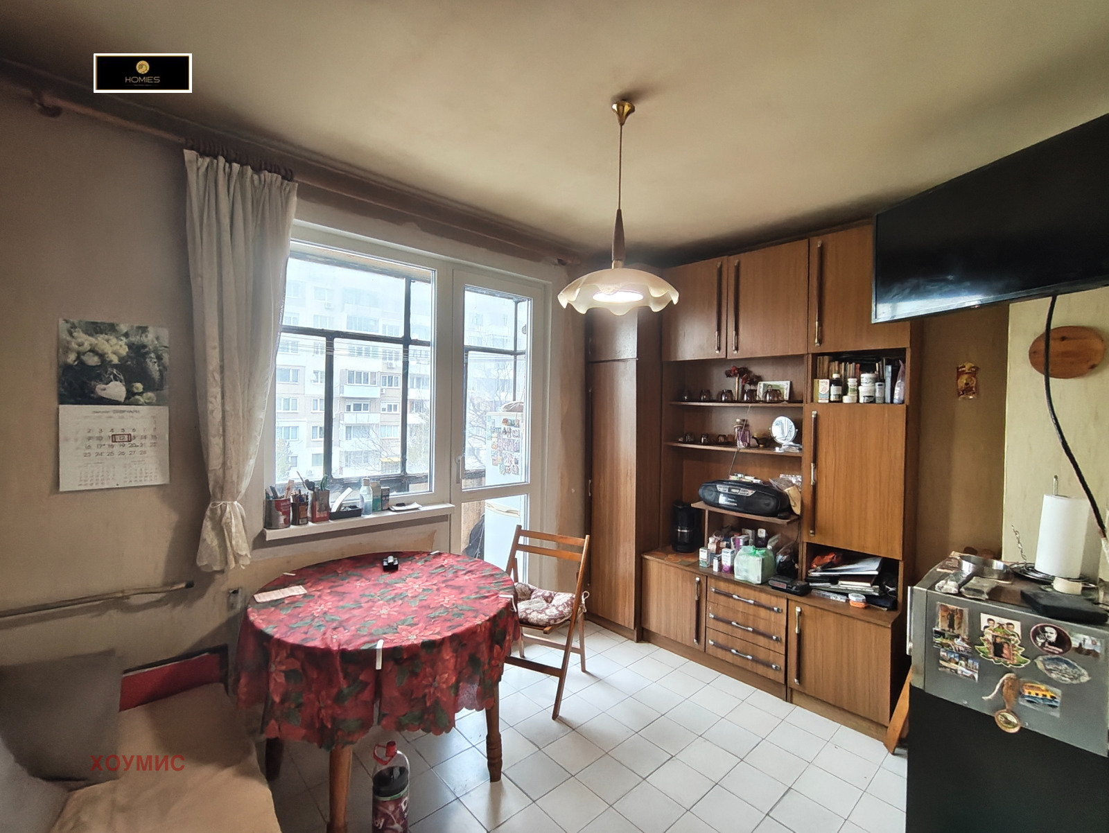 Светла кухня-трапезария с кръгла маса и дървена мебел