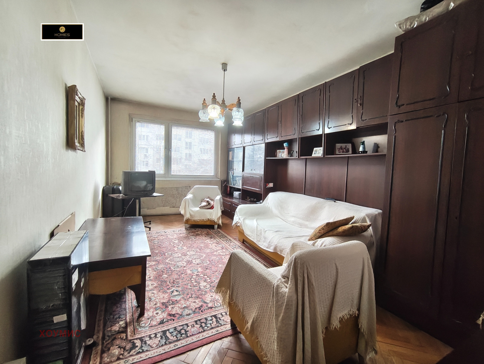 Светлина от прозорци осветяват хола със стари мебели