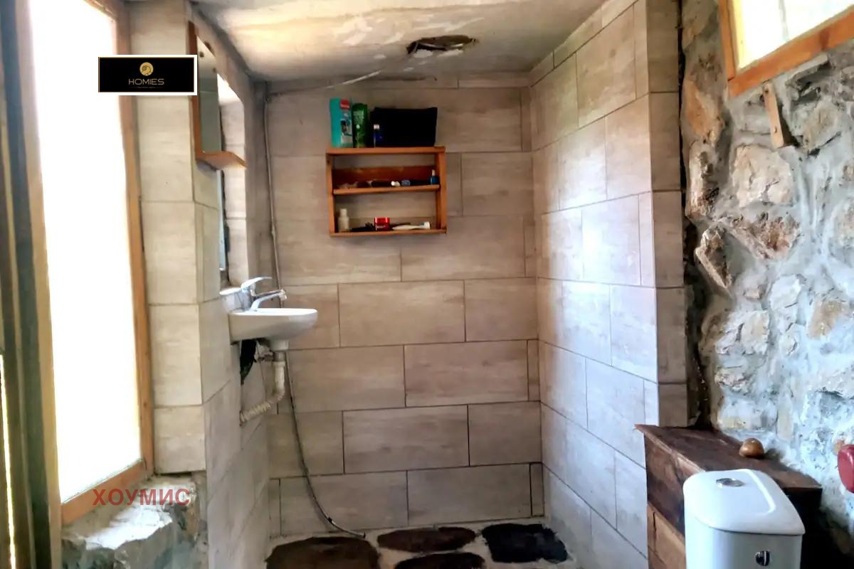 Small tiled bathroom with sink and toilet fixtures