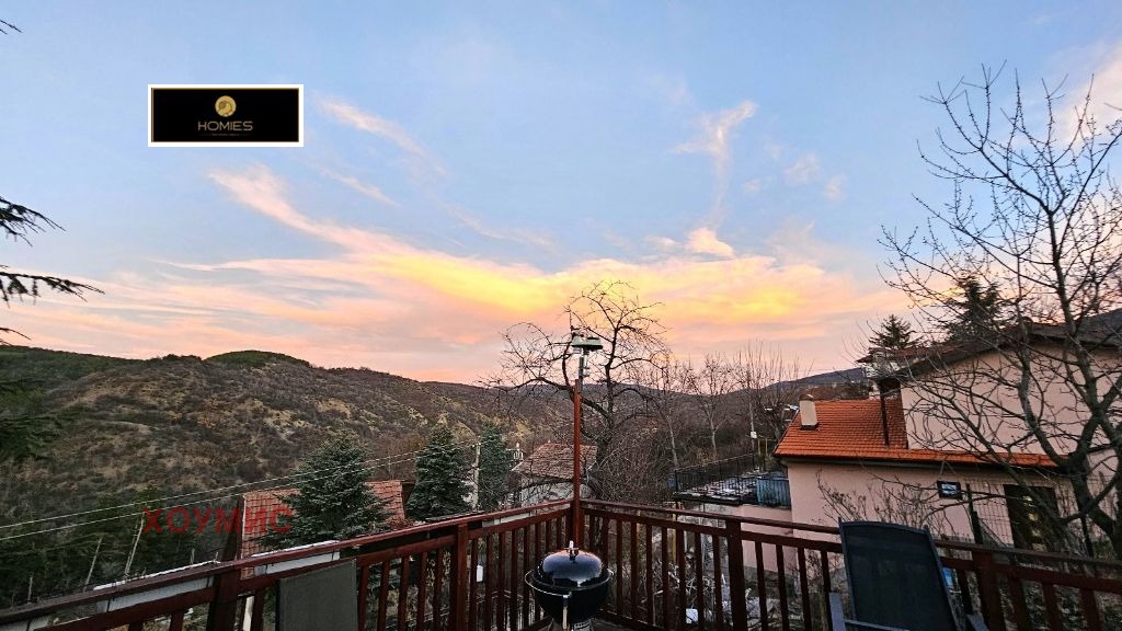 Terrace with wooden furniture and mountain view
