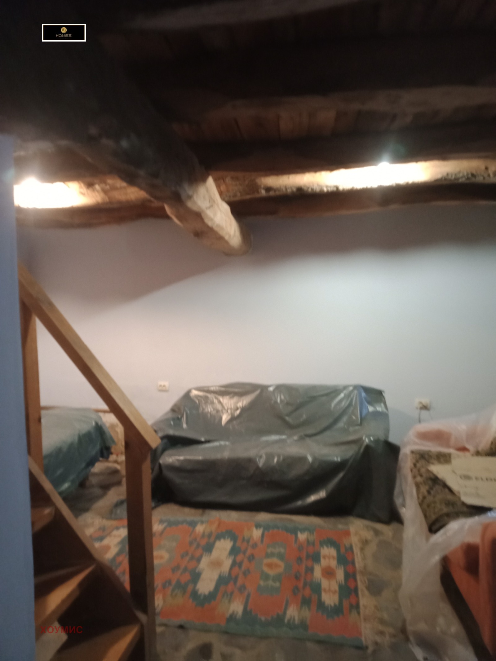 Просторна спална с дървени греди и зелени прозорци