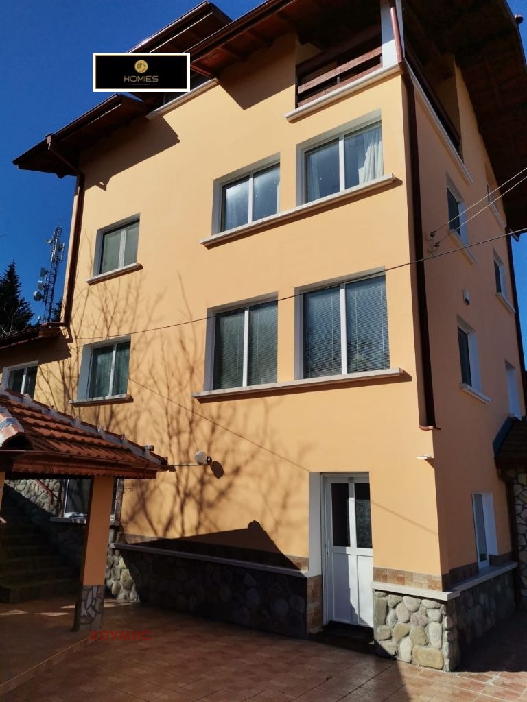 Жълта тристайна къща с кафяв покрив