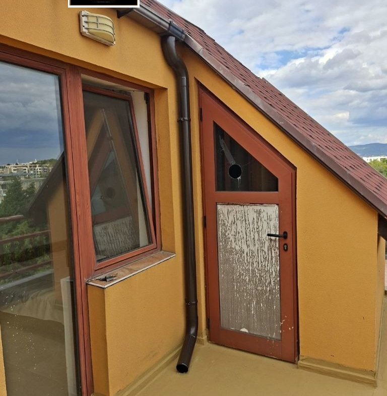 Yellow attic room with red door and window