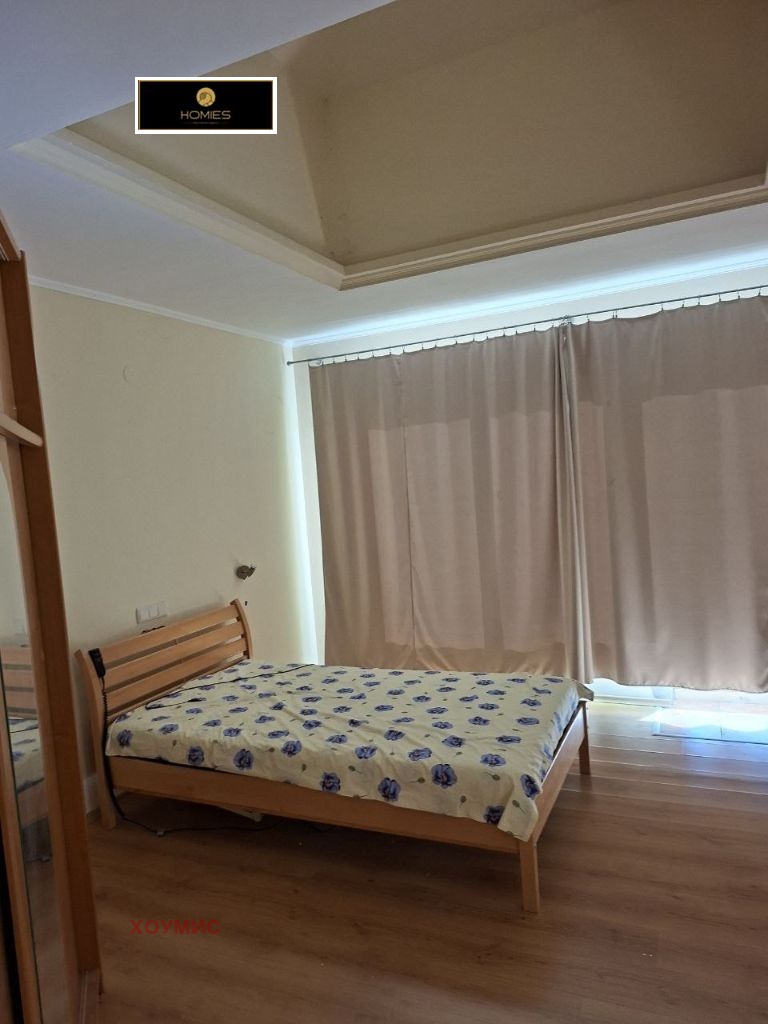 Spacious bedroom with wooden bed and modern ceiling