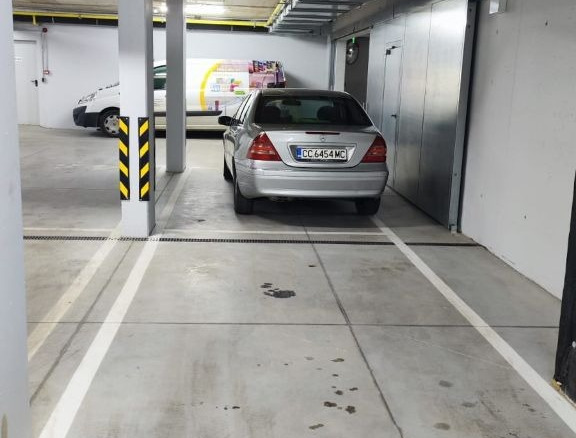 Underground parking space 27 with silver car parked