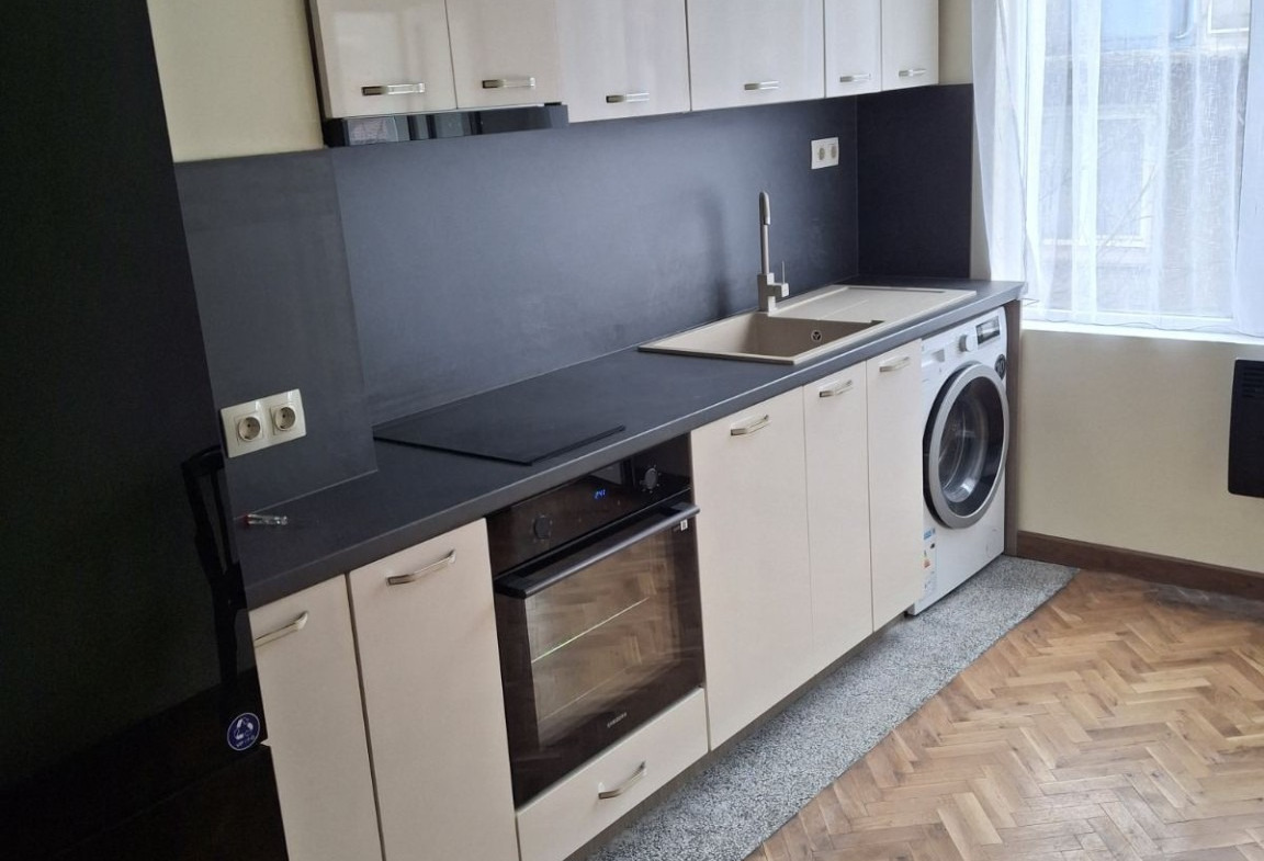 Модерна кухня с бели шкафове и черен плот