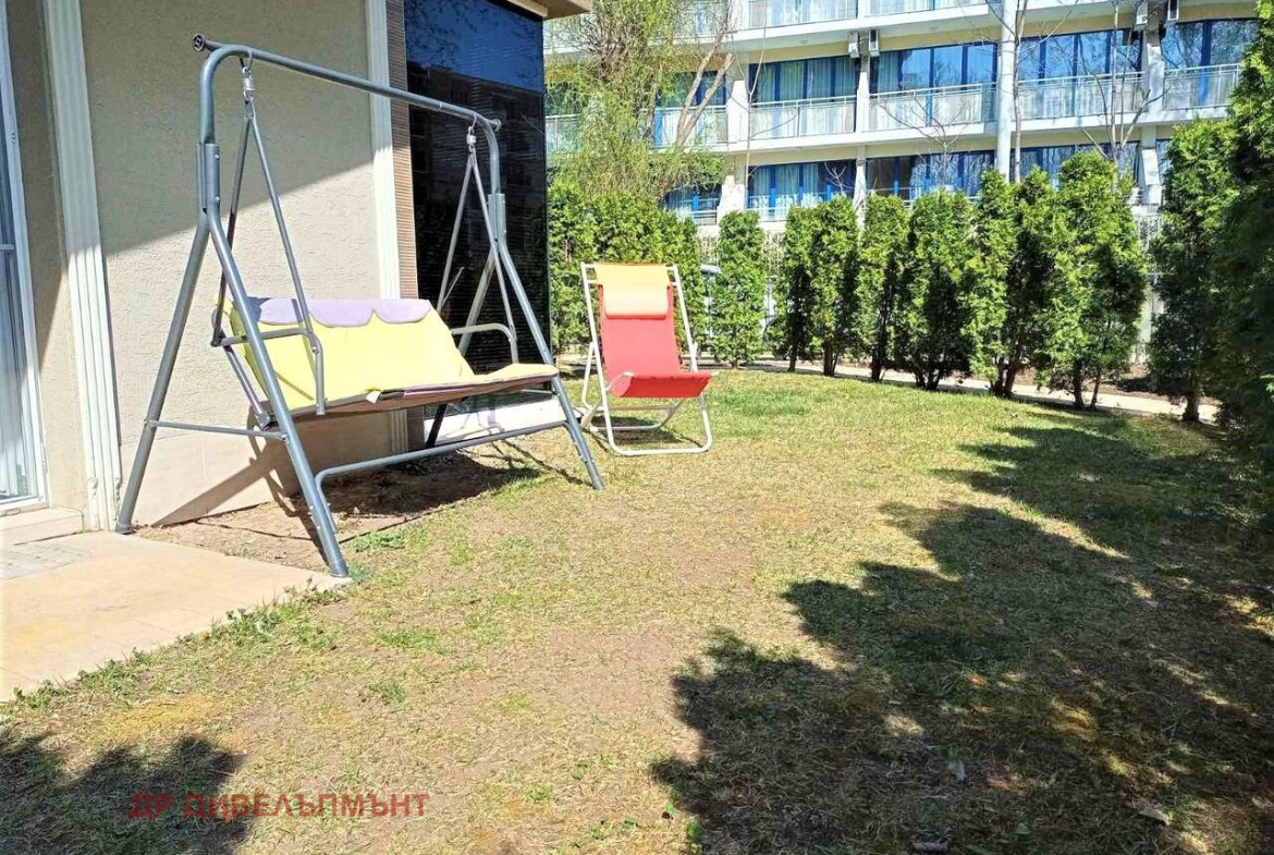 Градина на едностаен апартамент с люлка и червен шезлонг, Слънчев бряг
