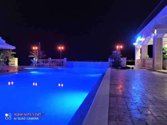 Illuminated swimming pool at night with blue lighting