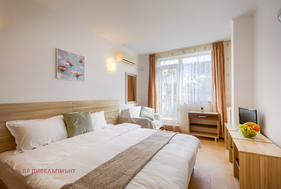 Comfortable bedroom with wooden bed and balcony