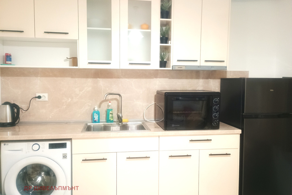 Modern kitchen with white cabinetry and black appliances