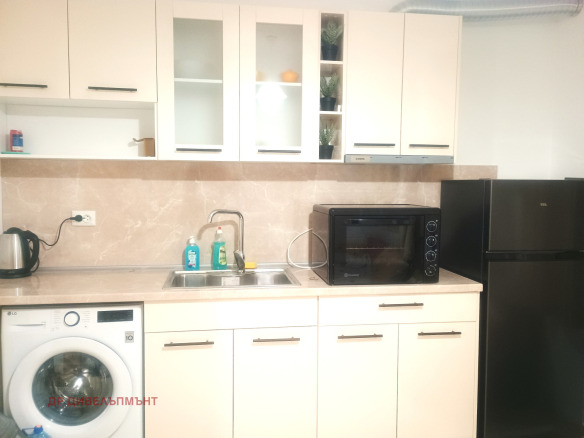 Modern kitchen with white cabinetry and black appliances