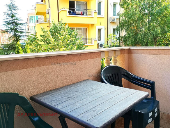 Terrace with black chairs overlooking yellow building