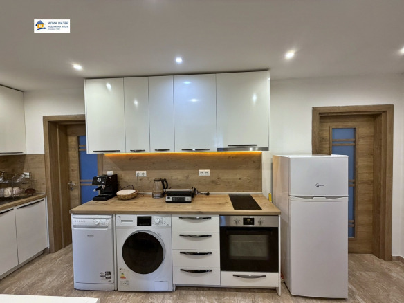 Modern kitchen with white cabinets and wood countertop