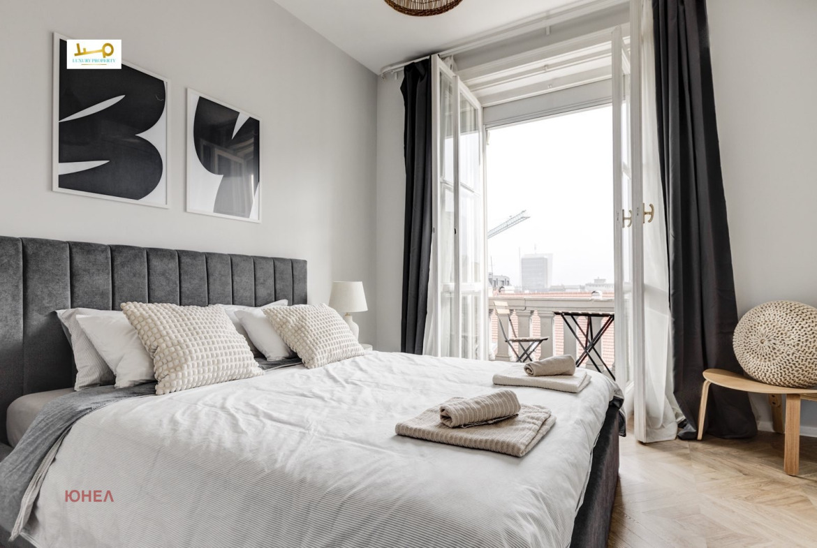 Bedroom with gray upholstered headboard and panoramic terrace