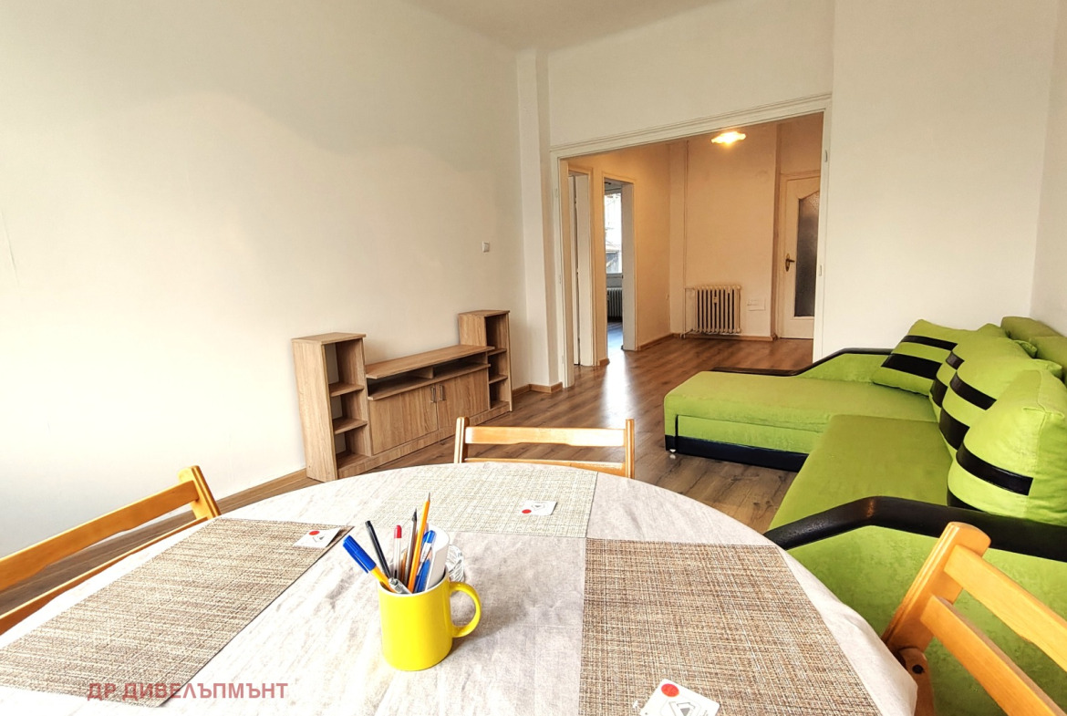 Spacious living room with green sofa and table