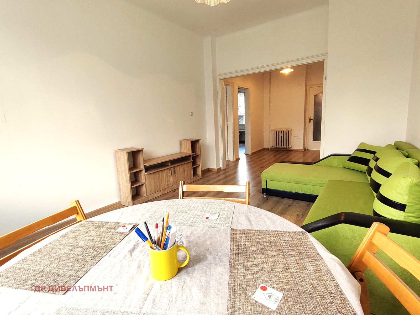 Spacious living room with green sofa and table