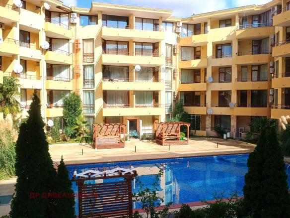 Yellow apartment complex with blue swimming pool below