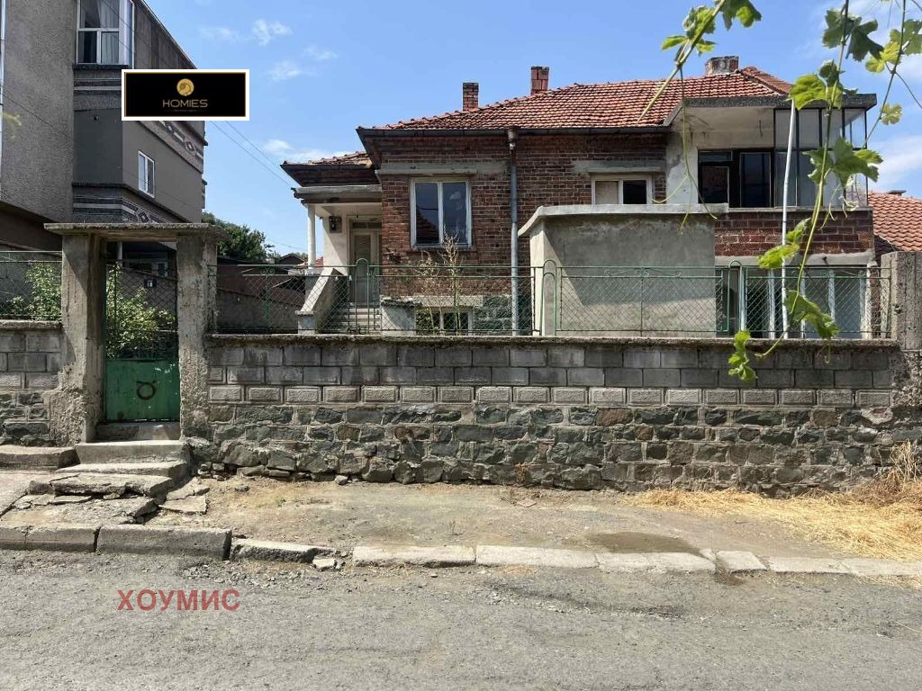 Къща с каменна ограда и метална врата спреди