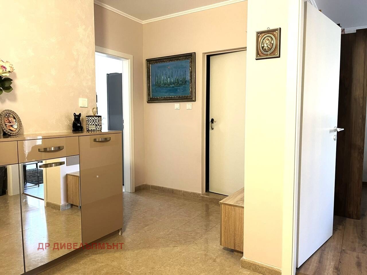 Hallway with beige cabinet, two doors, and painting on wall