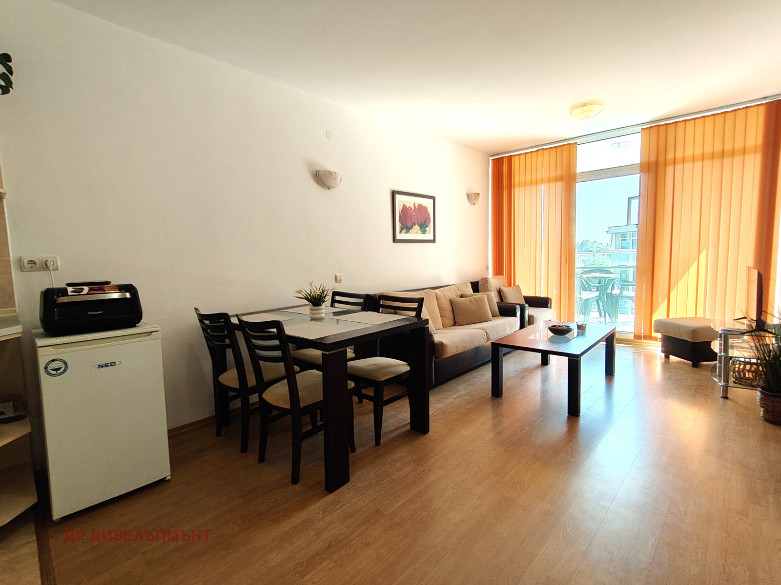 tristaen-apartament-95-kvm-pod-naem-kompleks-sani-holidey-nesebar-basein-parking-3 Светла всекидневна със софа и телевизор