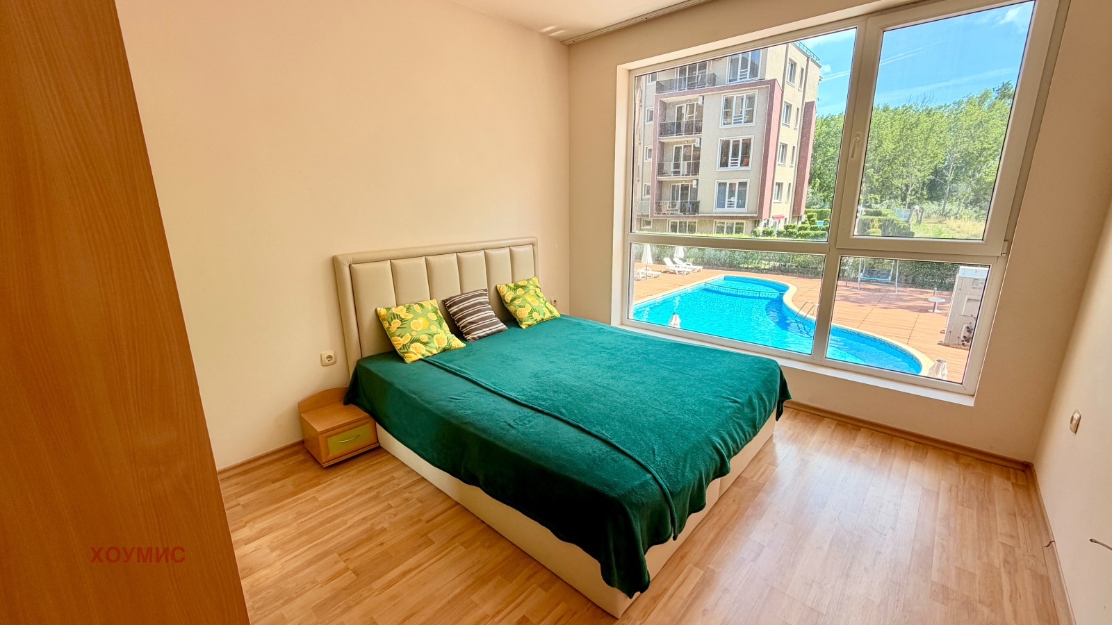 dvustaen-apartament-60-kv-m-prodava-se-slanchev-bryag-vtor-etazh-1 Спалня с двойно легло и поглед към басейна