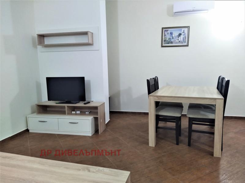 dvustaen-apartament-89-kvm-pod-naem-perla-nesebar-purva-liniya-more-2 Хол с диван, телевизор и дървена маса