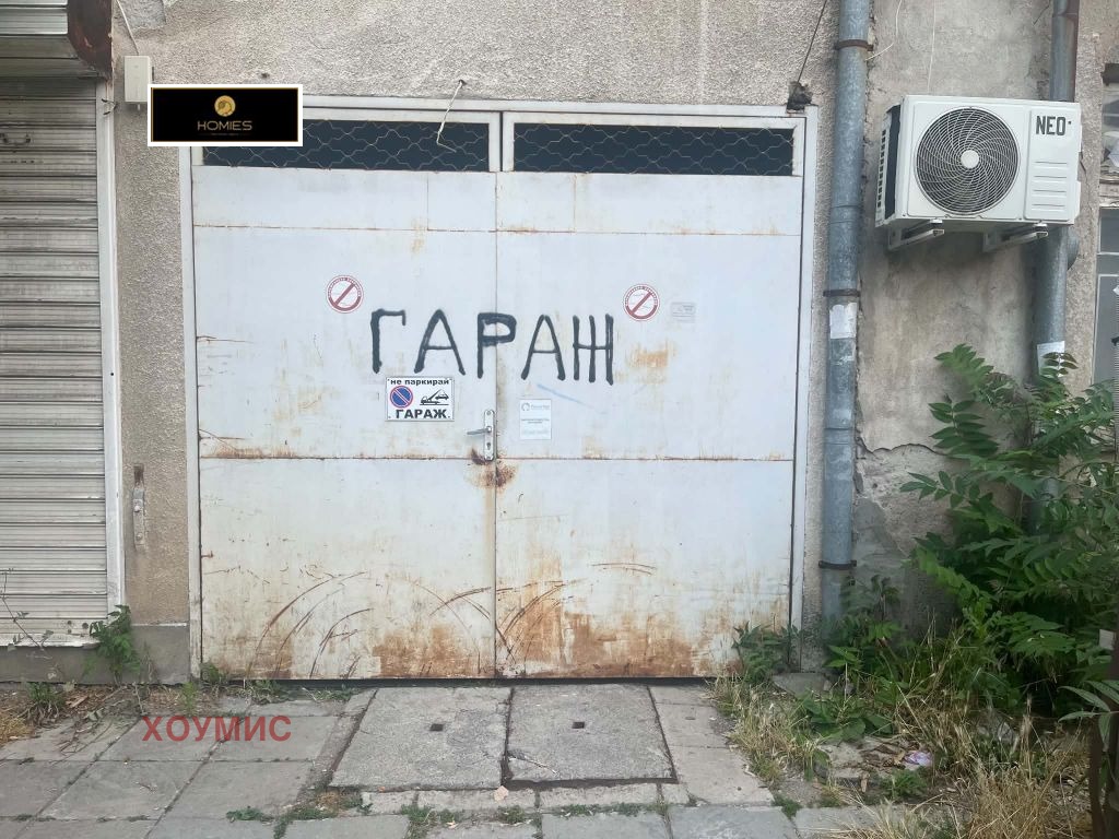Гараж с бели врати и ръжда от влага