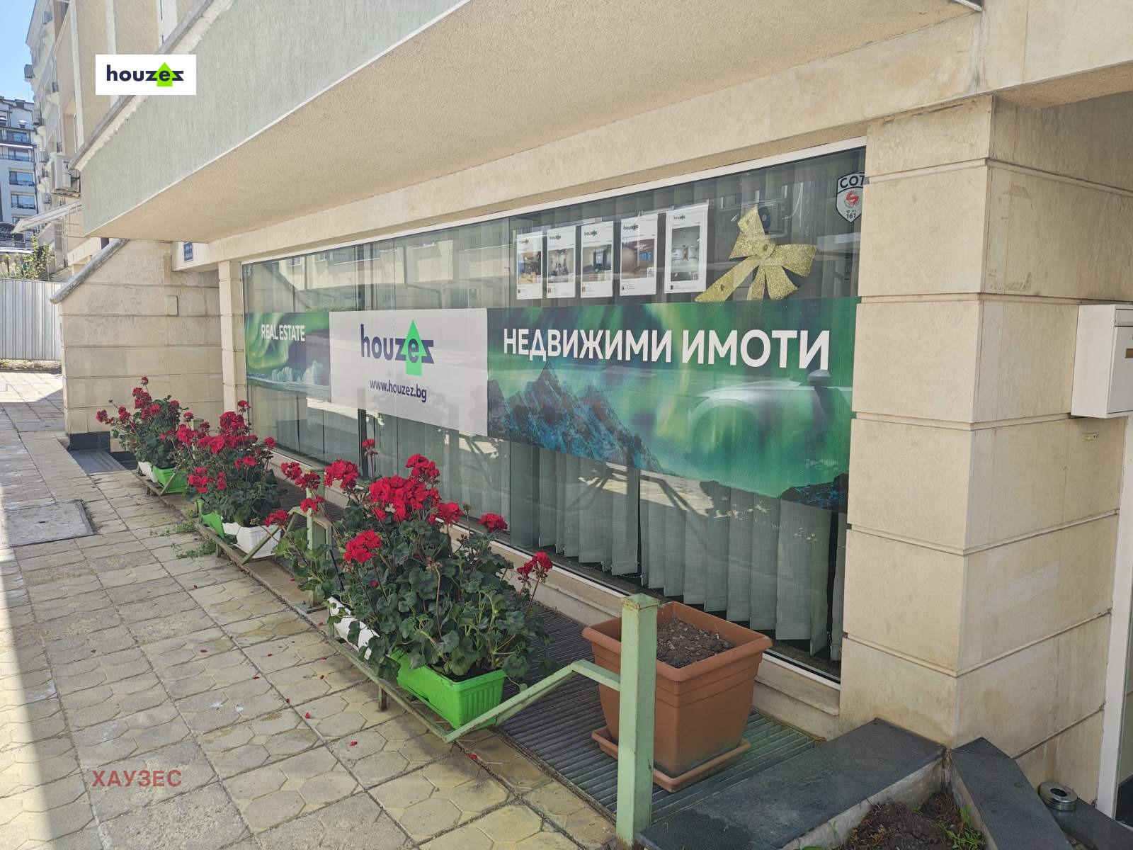 Витрина с зелени растения и реклама Houzex