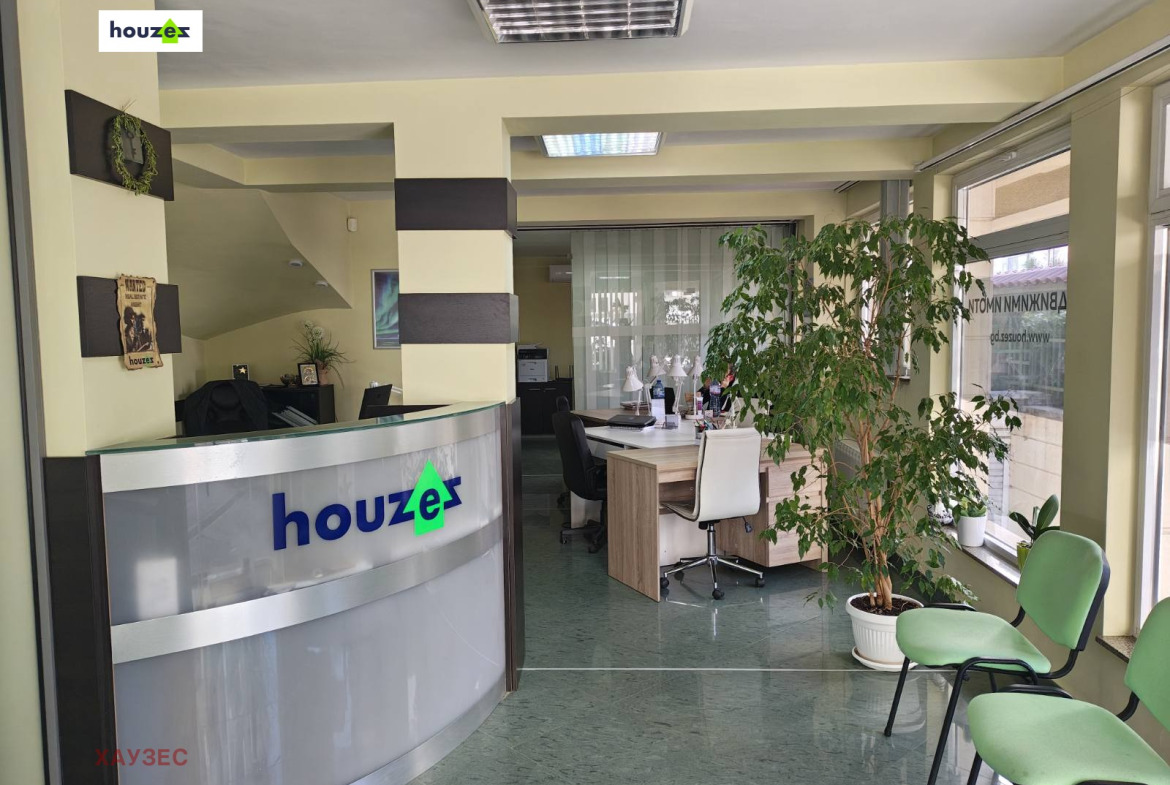 Рецепция с кръгъл плот и логото Houzex