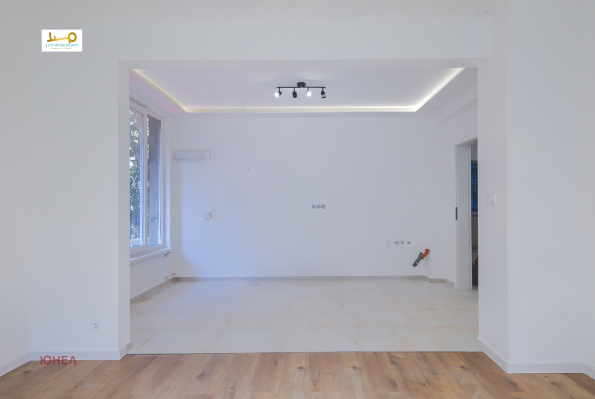 Open area with recessed ceiling, track lights, tile floor