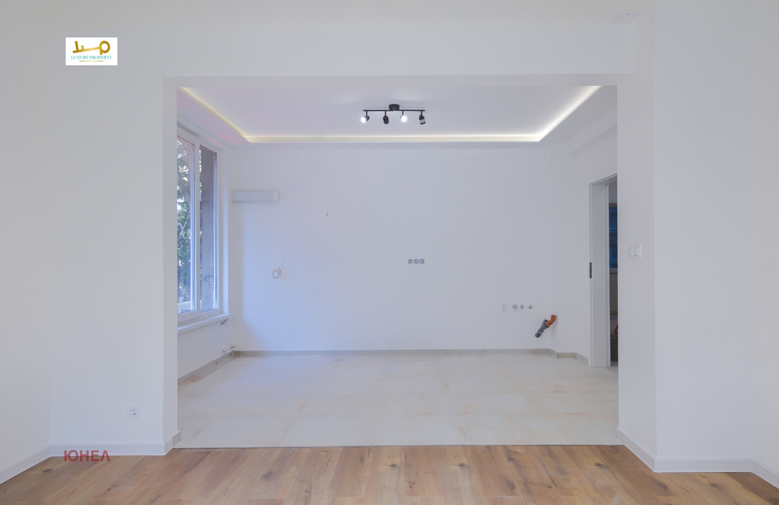 Open area with recessed ceiling, track lights, tile floor