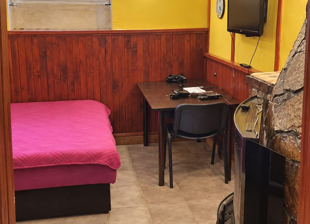 Bedroom with pink bed and television