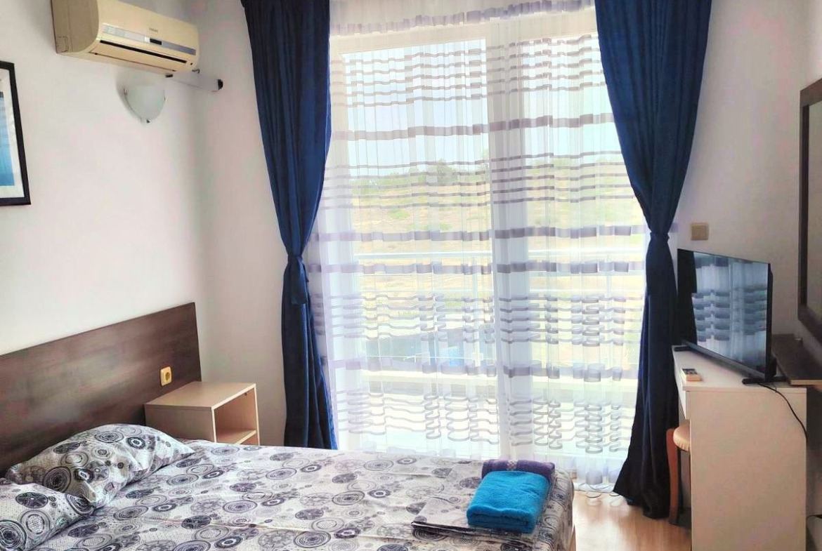 dvustaen-apartament-71-sqm-pod-naem-nesebar-kristal-biych-8 Modern bedroom with wooden bed and windows