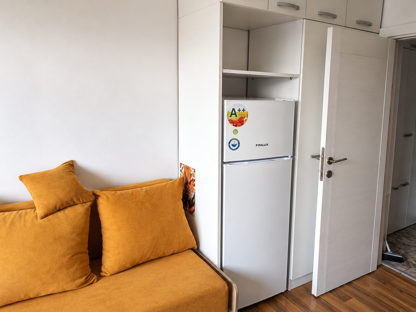 ednostaen-apartament-25-kvm-prodazhba-pavlovo-sofia-maze-4 Хол с оранжев диван и шкаф с часовник