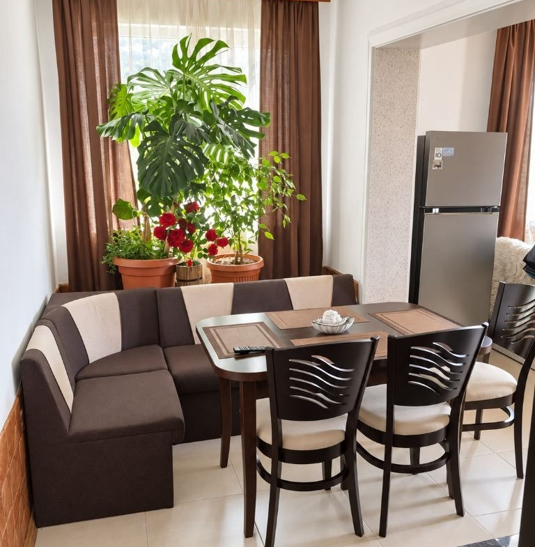 Floor of House in Tsarkva with corner sofa, dining table, chairs, plants, and refrigerator