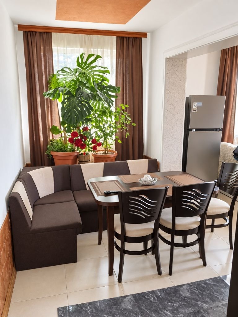 Floor of House in Tsarkva with corner sofa, dining table, chairs, plants, and refrigerator