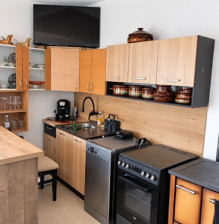 Kitchen with wooden cabinets, sink, dishwasher, stove, and coffee machine