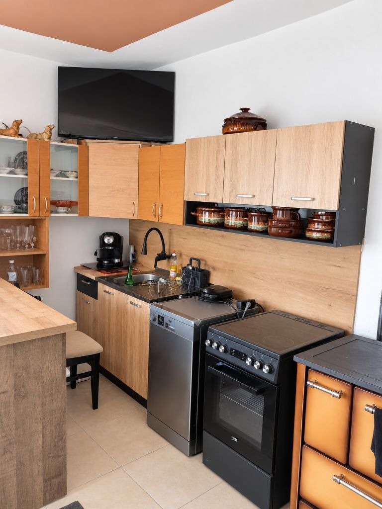 Kitchen with wooden cabinets, sink, dishwasher, stove, and coffee machine