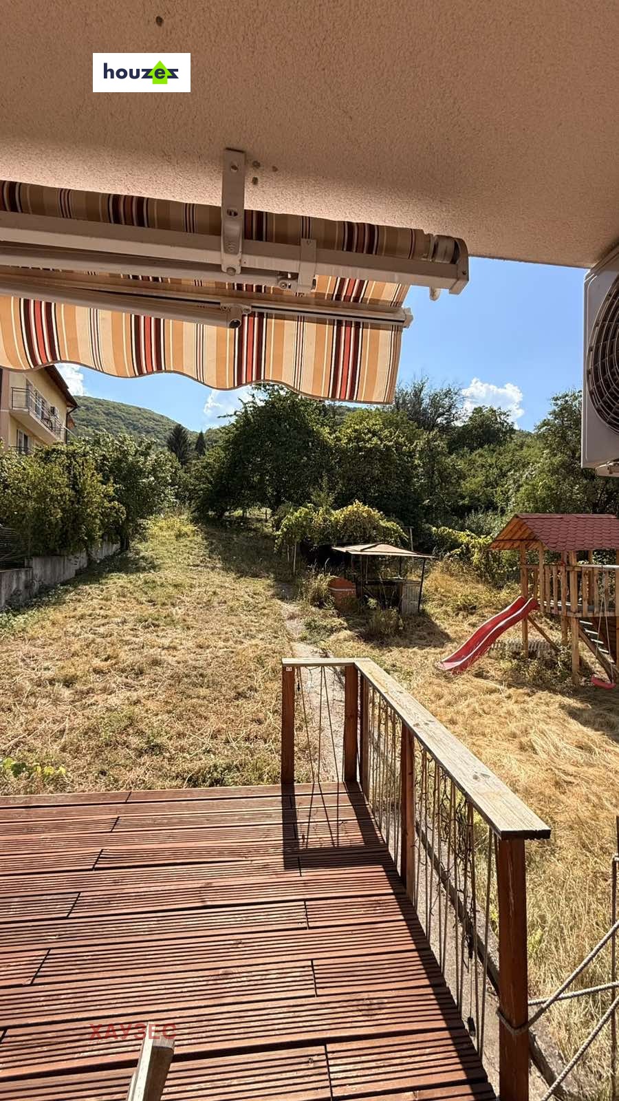Terrace with striped awning overlooking mountain landscape