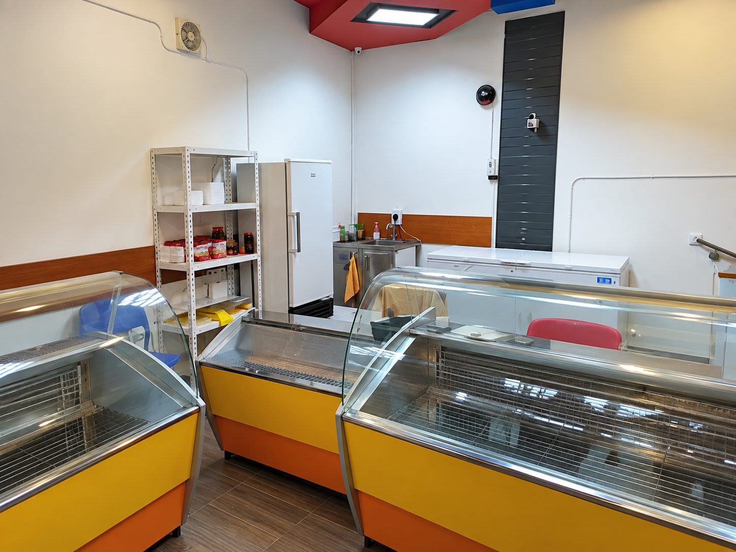 magazin-110-kvm-prodava-plovdiv-tsentar-s-ofis-i-biznes-3 Shop interior with yellow refrigerated display cases and shelving