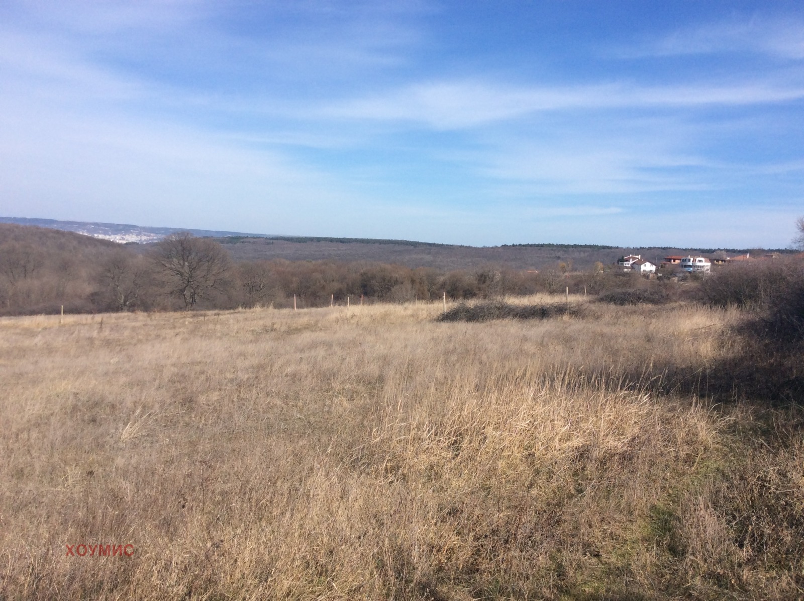 Land plot in Zvezditsa with dry grassland and distant houses