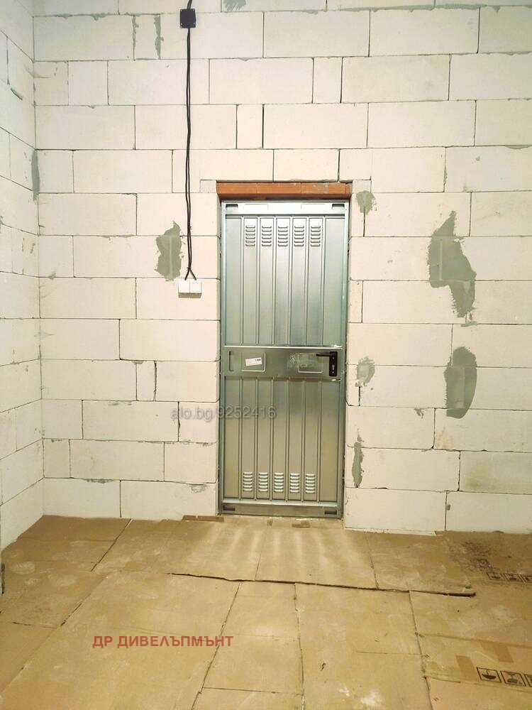 Metal security door with grate on brick wall