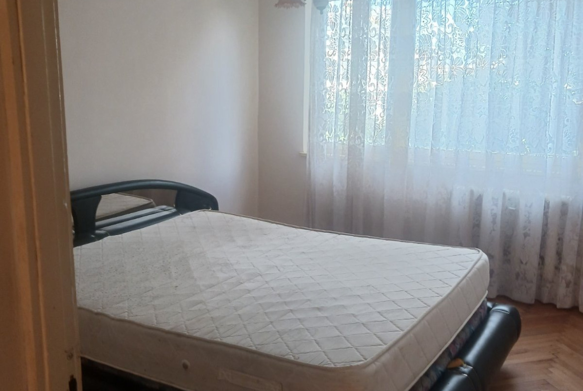 tristaen-apartament-90-sqm-pod-naem-lyulin-3-sofia-obzaveden-sklad-10 Спалня с двойно легло без спално бельо, паркетен под и прозорец с тюлена завеса
