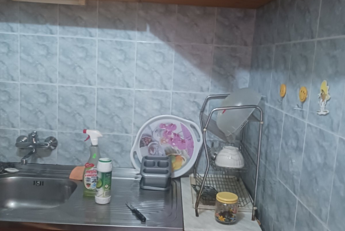 tristaen-apartament-90-sqm-pod-naem-lyulin-3-sofia-obzaveden-sklad-6 Кухненски плот с дървени горни шкафове, сиви плочки и поставка за чинии