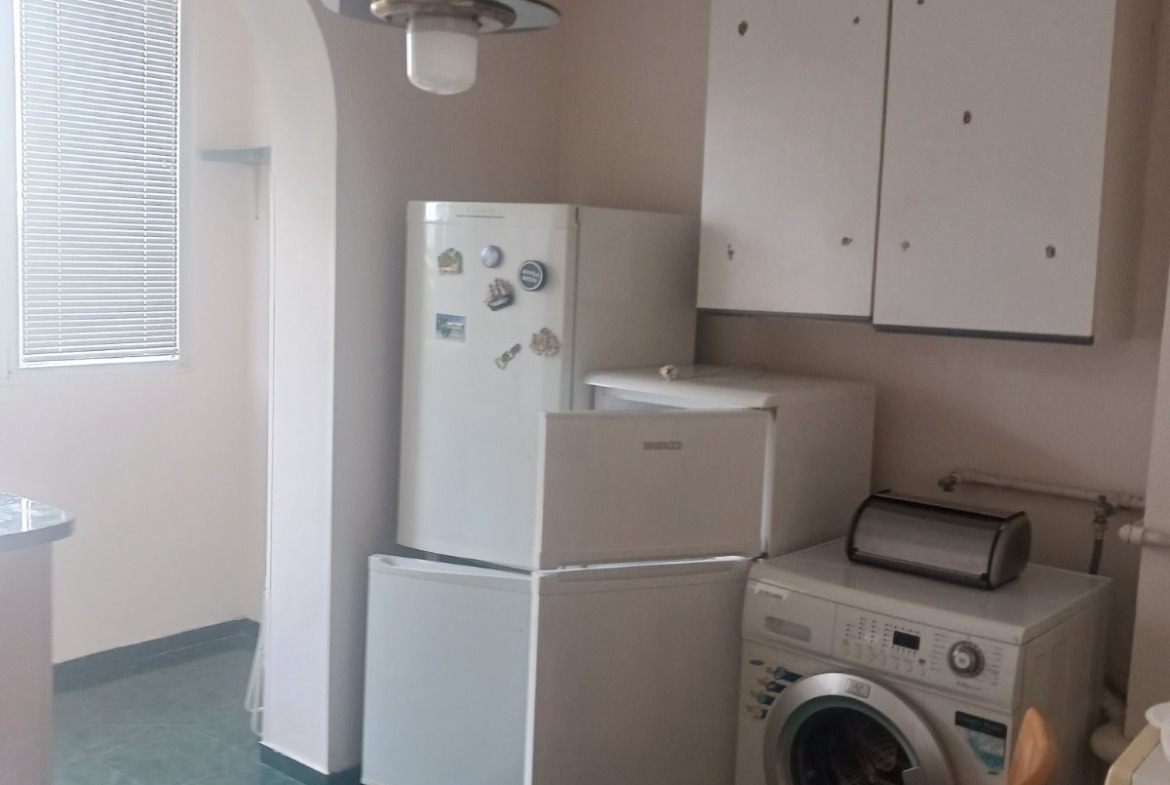 tristaen-apartament-90-sqm-pod-naem-lyulin-3-sofia-obzaveden-sklad-9 Кухненско пространство с два хладилника, перална машина, бели стенни шкафове и плочест под
