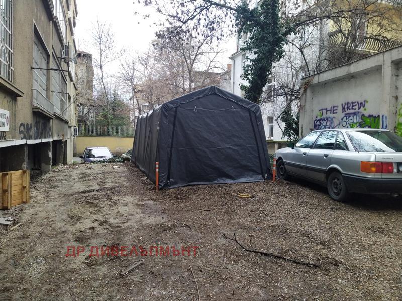 Underground parking with black tent and parked vehicles