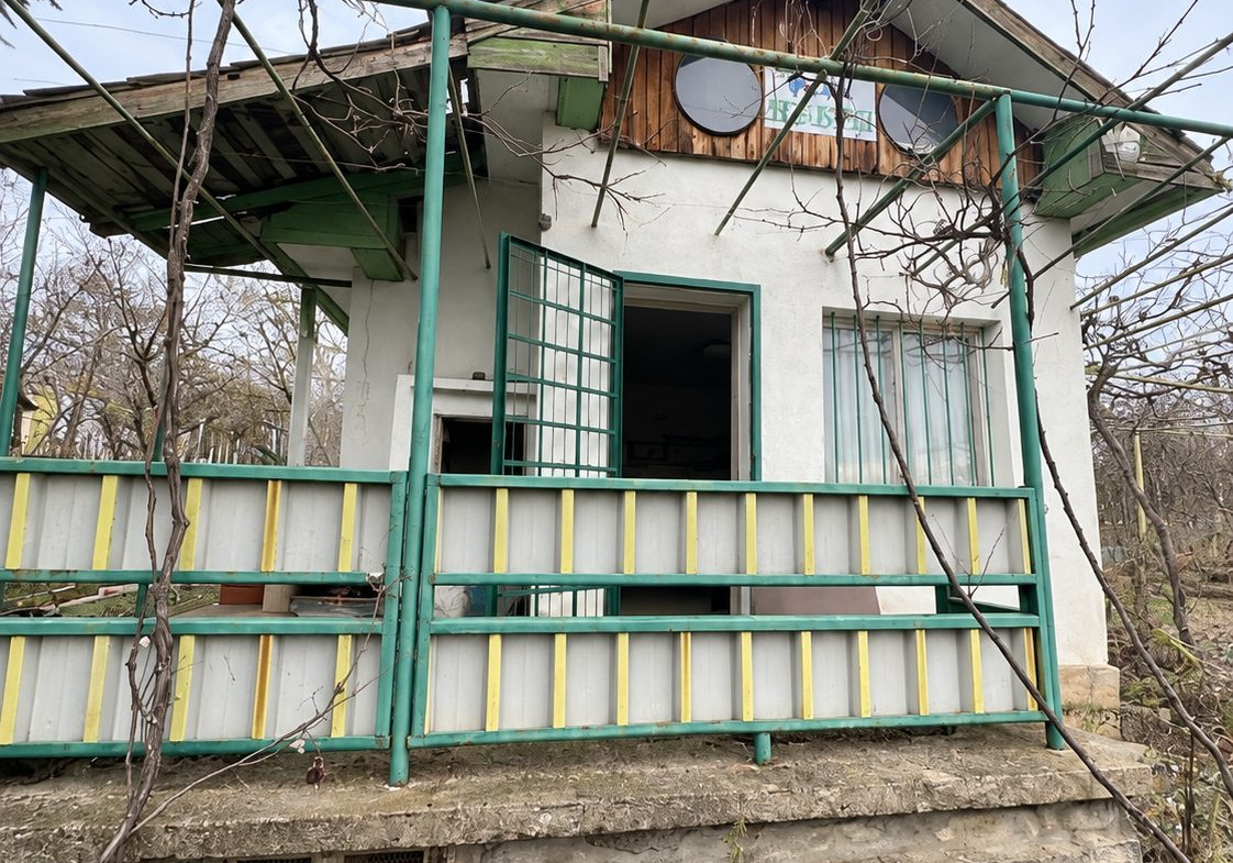 Small villa with green veranda and exterior stairs