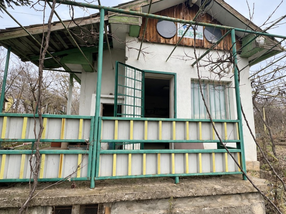 Small villa with green veranda and exterior stairs